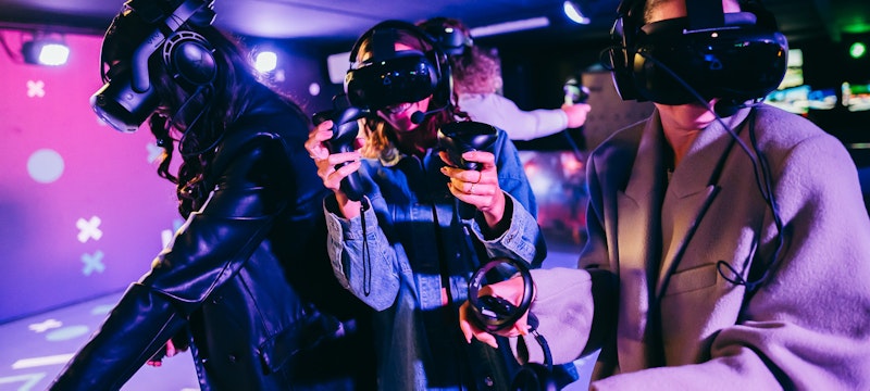 A group of girls enjoying the action-packed After the Fall VR game at A'DAM VR Game & Race Park, located in A'DAM Tower, Amsterdam, having fun and immersed in a thrilling virtual reality adventure.