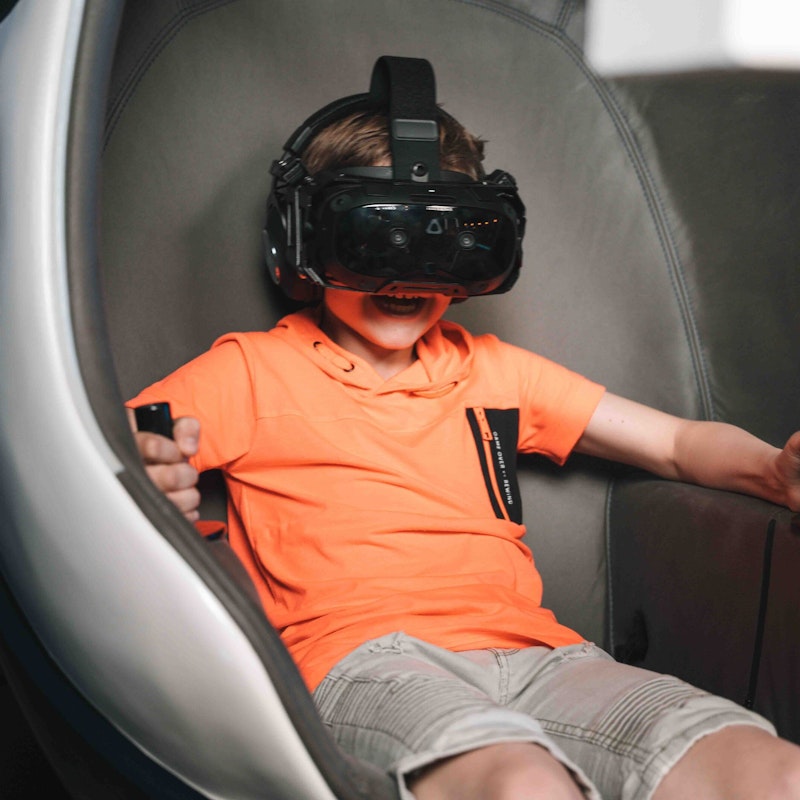 A kid fully immersed in the Scheveningen VR ride at Playrena, created by Jetstyle and The VR Boys, experiencing a thrilling and immersive virtual reality adventure.