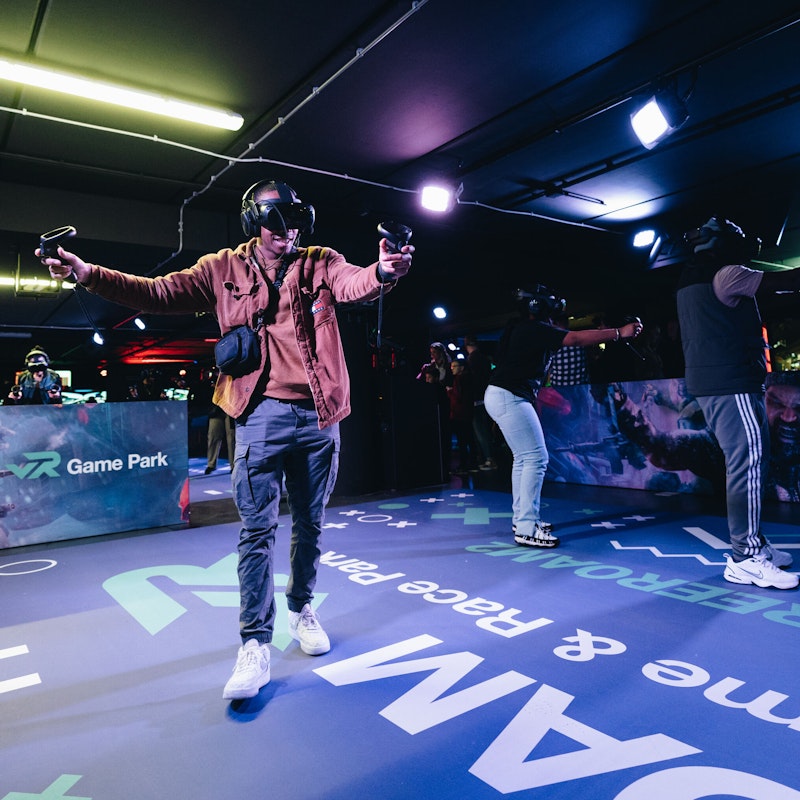 Group of people actively participating in the LBE free roam experience at A'DAM VR, fully immersed in a thrilling virtual reality adventure with interactive gameplay.