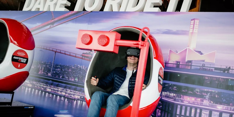 Someone fully immersed in a thrilling VR ride at A'DAM Lookout, located in A'DAM Tower, Amsterdam, experiencing a dynamic virtual reality adventure with stunning views of the city.