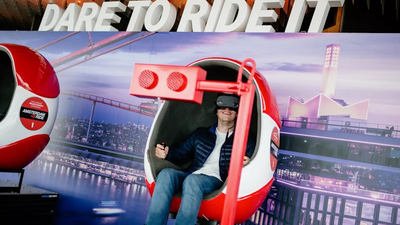 Someone fully immersed in a thrilling VR ride at A'DAM Lookout, located in A'DAM Tower, Amsterdam, experiencing a dynamic virtual reality adventure with stunning views of the city.