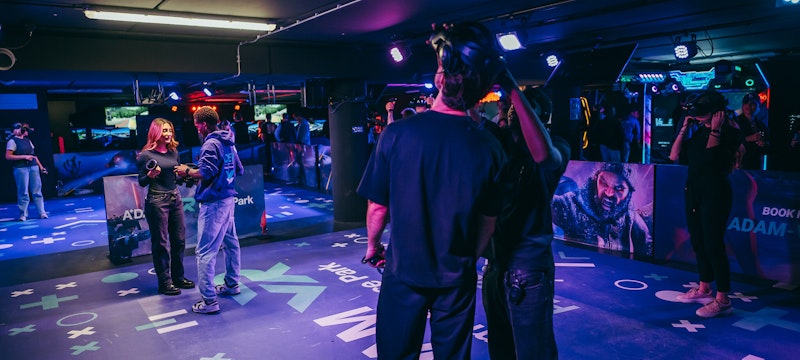 Staff guiding visitors as they start their immersive VR experience at A'DAM VR Game & Race Park, located in A'DAM Tower, Amsterdam. A thrilling introduction to the virtual reality adventures awaiting.