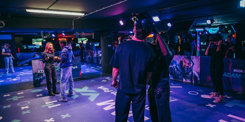 Staff guiding visitors as they start their immersive VR experience at A'DAM VR Game & Race Park, located in A'DAM Tower, Amsterdam. A thrilling introduction to the virtual reality adventures awaiting.